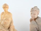 two statues of a woman and a man sitting next to each other