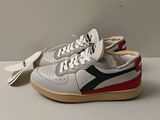des baskets blanches et rouges avec une bande noire et rouge sur la semelle