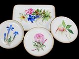 quatre assiettes ornées de fleurs peintes sur un fond noir