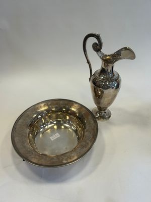a silver plate and a silver vase on a white table