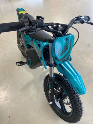 une photo d'une moto tout-terrain bleue garée dans un garage