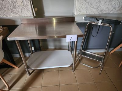 une table en acier inoxydable avec une chaise à côté
