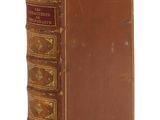 un vieux livre à la couverture brune et à la bordure dorée