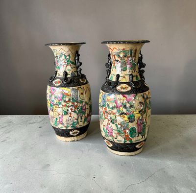 une paire de vases chinois posés sur une table, sur fond gris