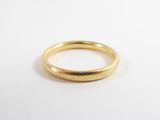 gros plan d'une bague en or sur une surface blanche