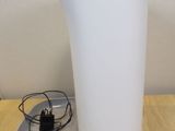 a white vase sitting on a table with a charger on it