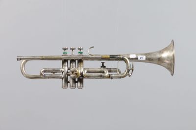 a silver trumpet that is flying in the air