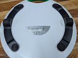 a white plate with a green handle on a wooden table