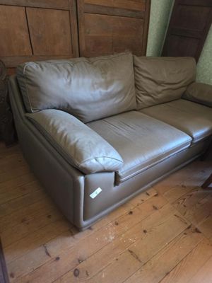 un canapé en cuir marron posé sur un parquet en bois massif