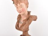 a clay bust of a woman with flowers on her head