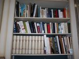 a bookshelf with many books on it in a room
