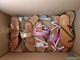 plusieurs paires de sandales dans une boîte en carton posée sur une table