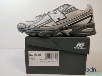 Les chaussures New Balance sont dans la boîte posée sur la table.