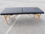 a black portable massage table sitting on top of a parking lot