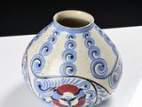a blue and white vase sitting on a white table