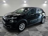 La Citroën noire est garée dans le garage, sur un sol à damier.