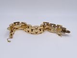 a close up of a gold bracelet on a white surface