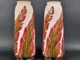 une paire de vases décorés de feuilles rouges et vertes