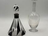 a glass bottle and a glass decanter on a white surface