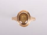 a close up of a gold ring with a brown stone in the center