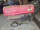 a red gas heater sitting on a cart in a garage