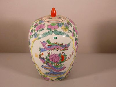 un vase blanc avec un couvercle rouge posé sur une table