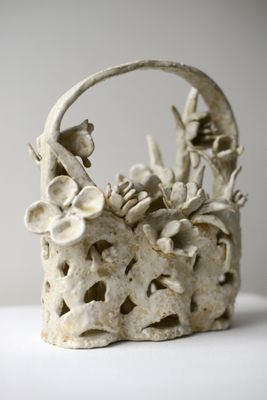 un panier blanc orné de fleurs, posé sur une table