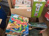 une boîte remplie de jouets et de livres posée par terre