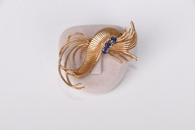a close up of a gold ring with blue stones on a white surface