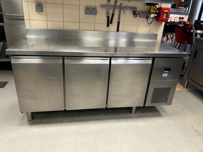 une grande cuisine en inox équipée d'un évier et d'un plan de travail