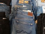 several pairs of jeans are stacked on top of each other