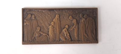 une photo d'une plaque en bronze représentant un groupe de personnes