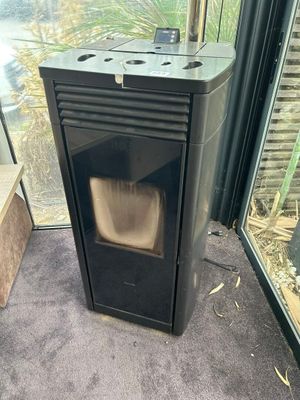 un poêle noir posé dans une pièce dotée d'une porte vitrée