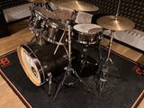 a drum set sitting on a rug in a recording room