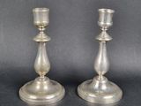 pair of silver candlesticks on a black background