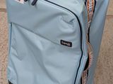 une valise bleue avec une étiquette, posée sur le trottoir