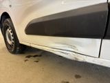 a car that has been painted white and has a denting on the side of it