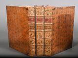 an old book is open on a table with a black background