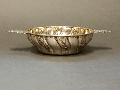 un bol en argent posé sur une table, avec une cuillère à l'intérieur