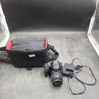 un appareil photo et un sac posés par terre l'un à côté de l'autre