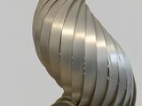 a metal sculpture of a spiral design on a pedestal