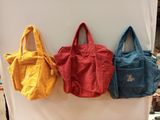 trois sacs sont accrochés au mur d'un magasin