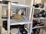 beaucoup d'assiettes et de casseroles sur les étagères de la cuisine