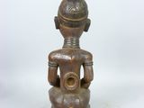 an old wooden statue of a man sitting on a stool