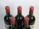 several bottles of wine are lined up in a row on a table