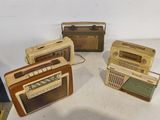 Plusieurs radios à l'ancienne sont posées sur une table
