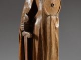 une image représentant une statue en bois d'un homme tenant un bouclier