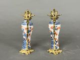 pair of blue and white vases with flowers on them on a gray surface