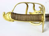 a sword with a gold handle on a white surface
