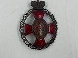 une image représentant un insigne rouge et noir orné d'une couronne